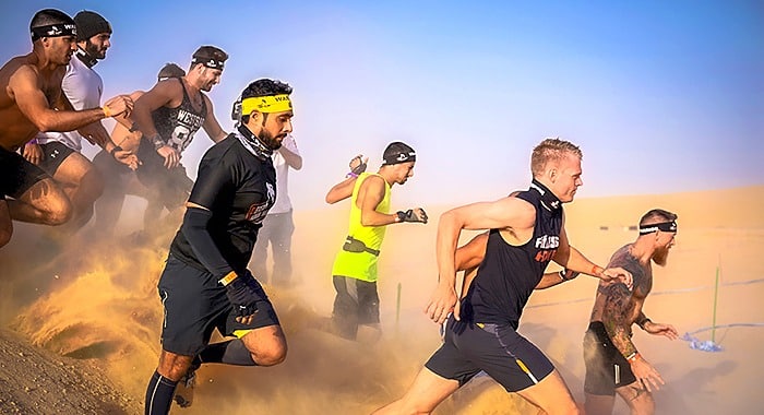 Participants tackling heart-pumping obstacles at the Desert Warrior Challenge in Dubai, UAE's only surviving homegrown obstacle course brand, known for its thrilling atmosphere and top-tier organization.