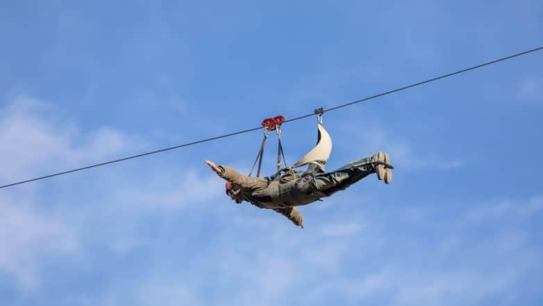 Thrill-seeker racing along the 1.5km AlUla Zipline at Adventure Hub, Saudi Arabia, reaching speeds of up to 120 km/h while enjoying breathtaking mountain scenery.